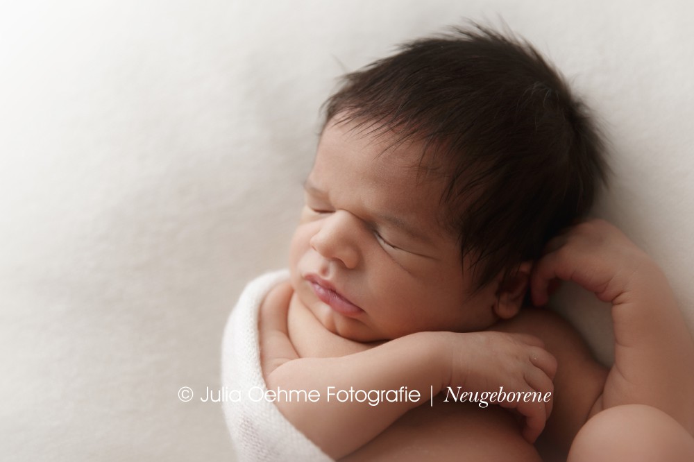 baby junge bei neugeborenenshooting auf weißer decke und mit weißem tuch von julia oehme fotografie in leipzig und halle